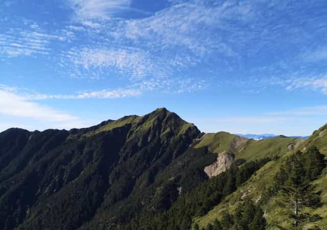 奇萊山稜線與綠色山坡在藍天白雲下延伸